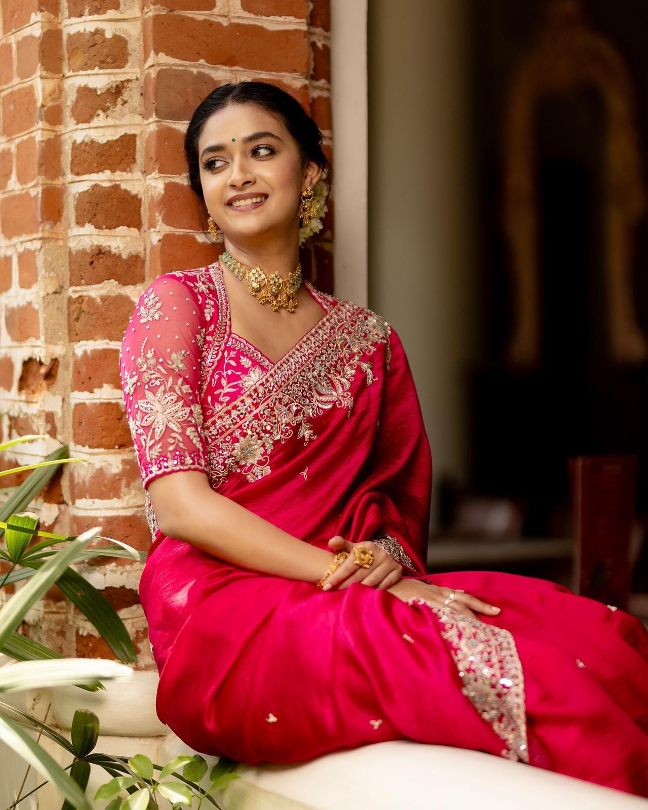 Dress up like a showstopper, just like Keerthy Suresh, in a stunning red silk saree adorned with golden embellishments and intricately worked borders. Pair it with a heavily embroidered halter-neck blouse, and complete the look with a golden choker, statement jhumkas, and a neatly tied bun wrapped in fresh gajra.